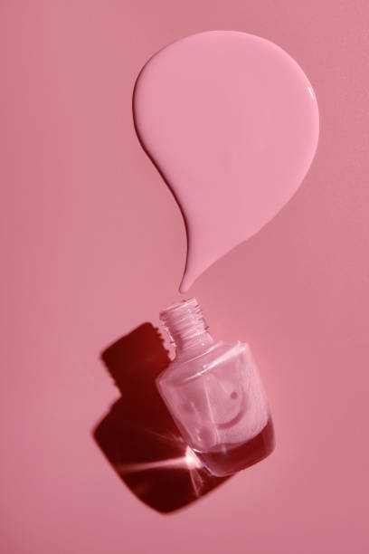 bottiglia rovesciata con smalto rosa su sfondo rosa. - nail polish foto e immagini stock