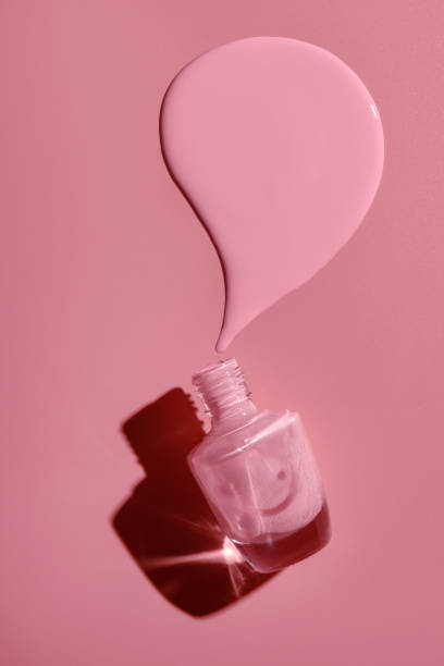 overturned bottle with pink nail polish on a pink background. overturned bottle with pink nail polish on a pink background. nail polish stock pictures, royalty-free photos & images