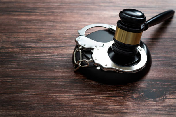 istock Gavel and handcuffs on wooden table 1407552214