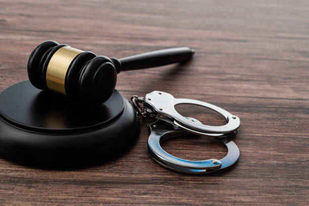 istock Gavel and handcuffs on wooden table 1407552434