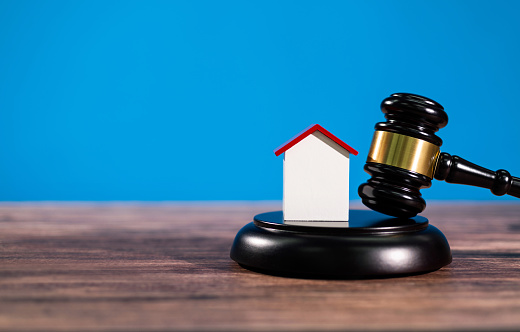 Gavel and model house on the table.