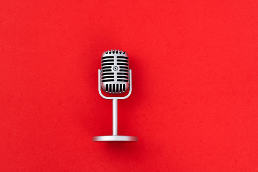 Retro microphone on red background.