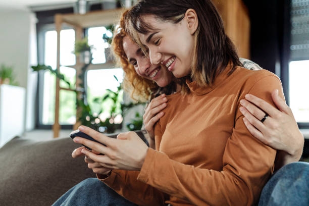 istock Female young couple using smart phone at home 1407553258