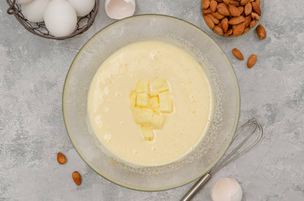 istock Recipe step by step. The process of making Italian cantucini cookies. Whipped eggs with sugar and butter in a bowl on a gray concrete background. Top view. 1407555373