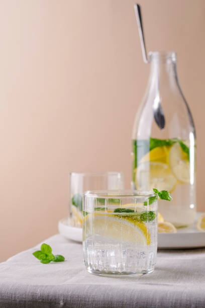 istock Refreshing summer drink with lemon and mint on the table. Lemonade in glasses and bottle 1407558121