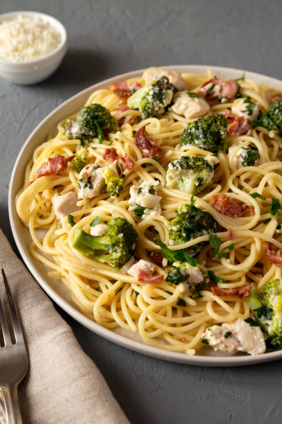 istock Homemade Chicken Bacon Broccoli Alfredo on a plate on a gray surface, side view. 1407559017