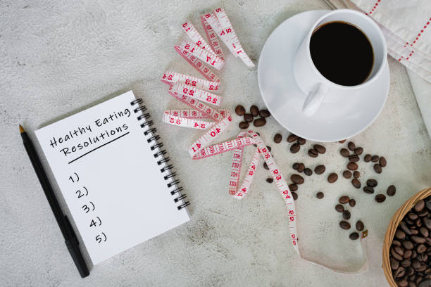 istock Healthy eating resolutions on note book with cup, coffee beans and measure tap. 1407561265