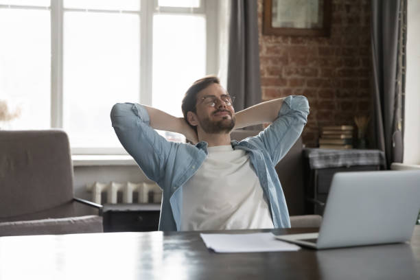 istock Office employee put hands behind head enjoy break at workplace 1407561790
