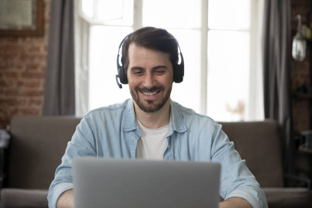 istock Smiling businessman wear headset use laptop having communication through videoconference 1407561875