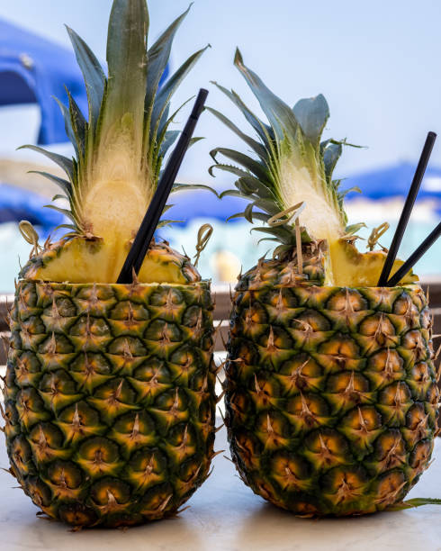 due pinacolada coctails in frutta fresca di ananas sul tavolo del bar. - umbrella two objects cocktail drink foto e immagini stock