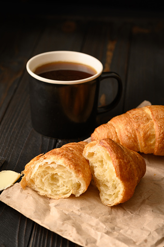 Croissants with coffee on a wooden background.