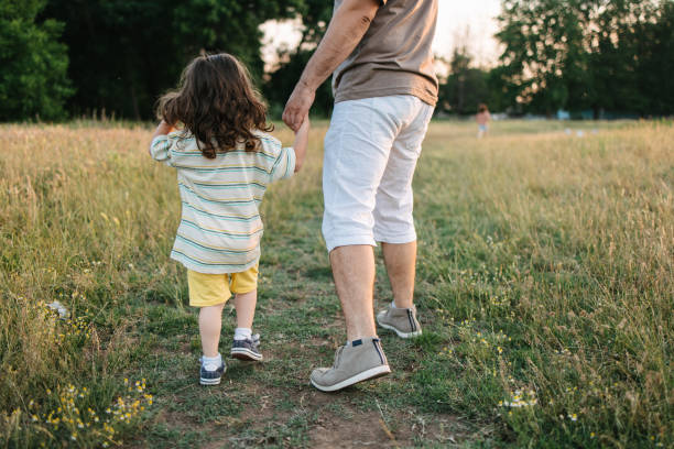 istock Dad walking his son on the grass field 1407572198