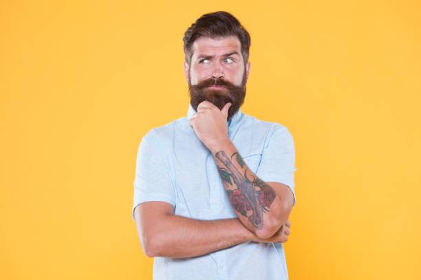 istock thoughtful bearded man with hairstyle in white shirt, decision 1407574314