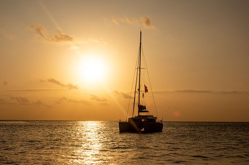 Sunset in the Indian Ocean. Silhouette of a sailing catamaran anchored against the backdrop of the evening sun