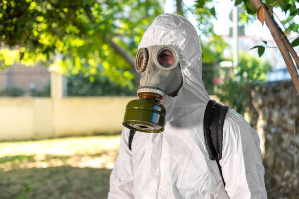 istock Man spraying insecticide on grass in lawn. 1407581822