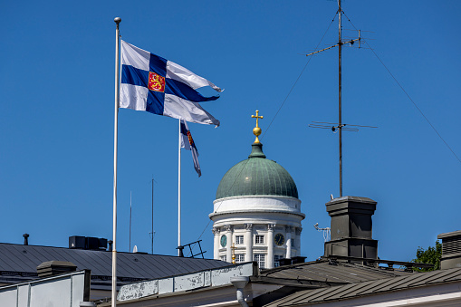 Helsinki, Finland - Jun 25th 2022: Midsummer is a public holiday in Finland and Finnish flags are flying over Helsinki buildings.