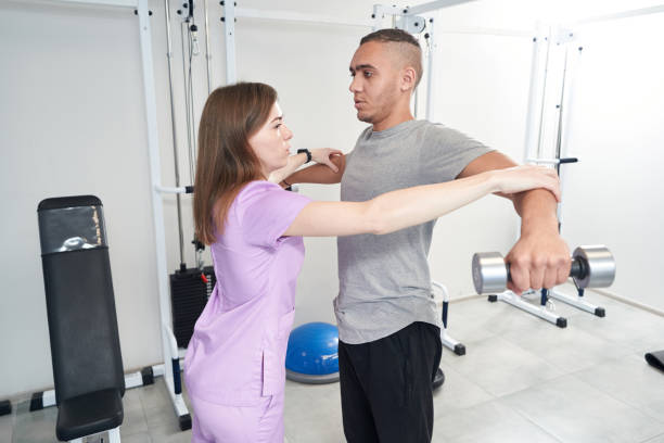 physiotherapist helping man to perform rehabilitation exercise ripl fitness
