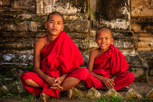 Two young Buddhist monks posing in an ancient temple, Myanmar