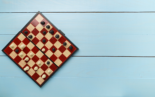 Chess on wooden background, top view.
