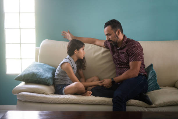 istock Father and daughter sitting on sofa and discussing 1407603306