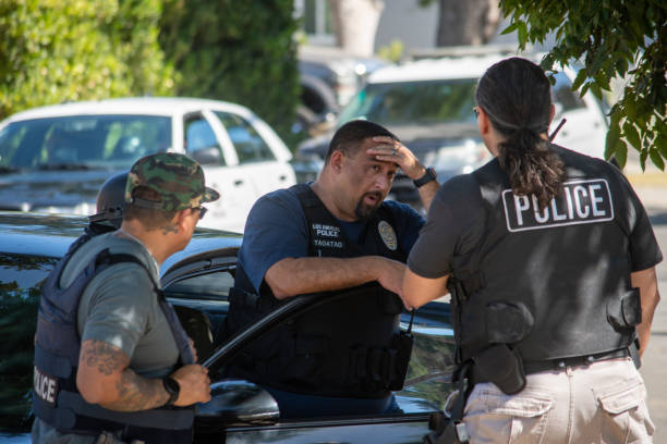 un groupe de travail multi-agences comprenant des détectives des stupéfiants du lapd se déroule dans une rue communautaire avant une descente d’application de la loi sur les drogues. - northridge photos et images de collection