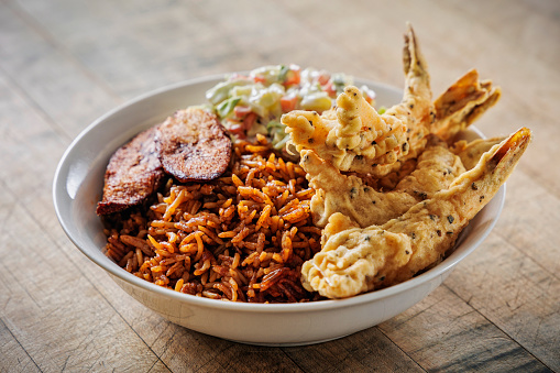 African-style shrimp bowl with Jollof rice, plantain and coleslaw