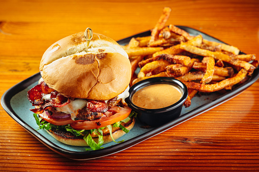 American-style bacon cheeseburger with French fries and sauce