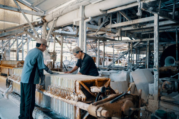 Long rubber-fabric tape reinforced with textile on wooden rods on tension station and compensator on production line. Car tires manufacturing on factory equipment