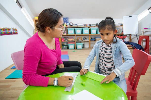 istock teacher teaches blind girl to write braille 1407605601
