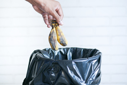throwing banana in a garbage bin ,