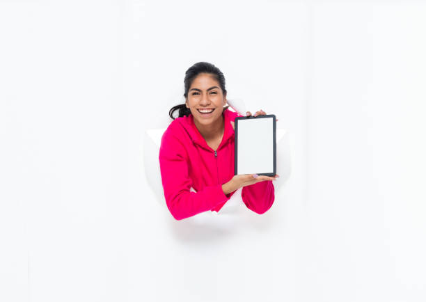 One person of aged 20-29 years old who is beautiful with black hair generation z young women in front of white background wearing sweatshirt who is smiling and using touch screen