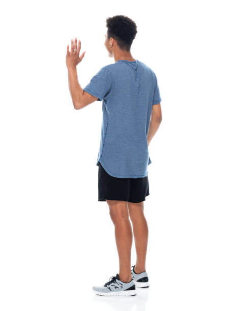 African ethnicity male standing in front of white background wearing t-shirt stock photo