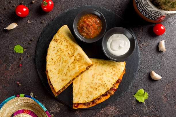 istock Quesadilla with beef, cheese, bbq sauce and sauces on dark stone plate top view 1407619719