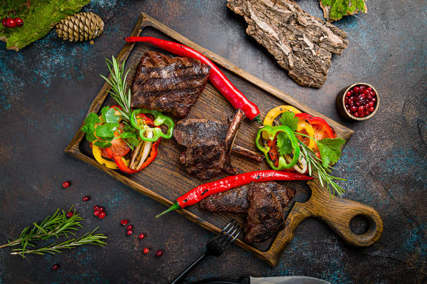 istock Venison steak with lingonberry sauce and different meat on the board top view 1407619740