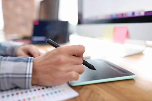 istock Stylus in hand from graphics tablet closeup 1407627320