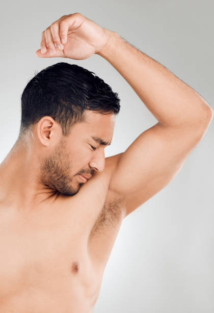 istock Studio shot of a handsome young man looking disgusted by his smelly armpits while posing against a grey background 1407627354