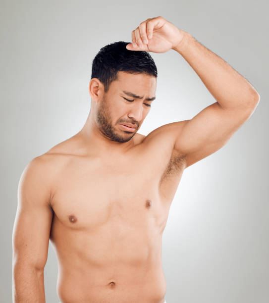 istock Studio shot of a handsome young man looking disgusted by his smelly armpits while posing against a grey background 1407627355
