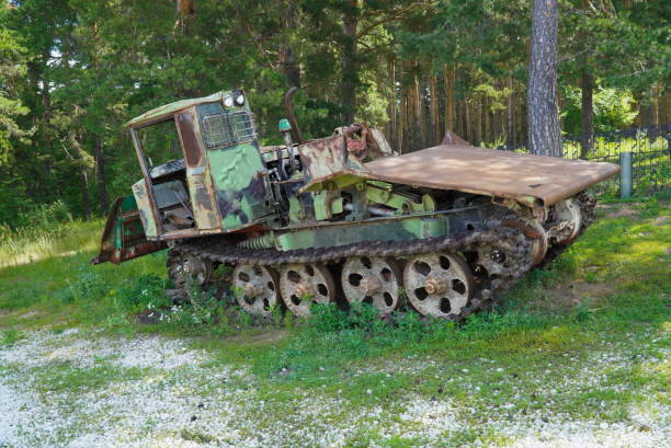 An Rusty old tractor abandoned in the forest on a caterpillar track.