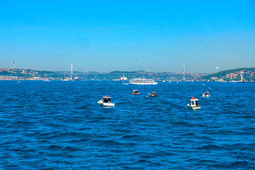 Istanbul-Turkey, May 21, 2022; Bosphorus Bridge / July 15 Martyrs' Bridge in Istanbul. They’re some fisherman boats.