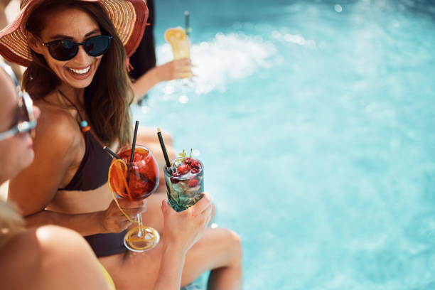 쾌활한 여자는 수영장에서 여름날 친구들과 토스트를하면서 재미있게 지냅니다. - adult beverage 뉴스 사진 이미지