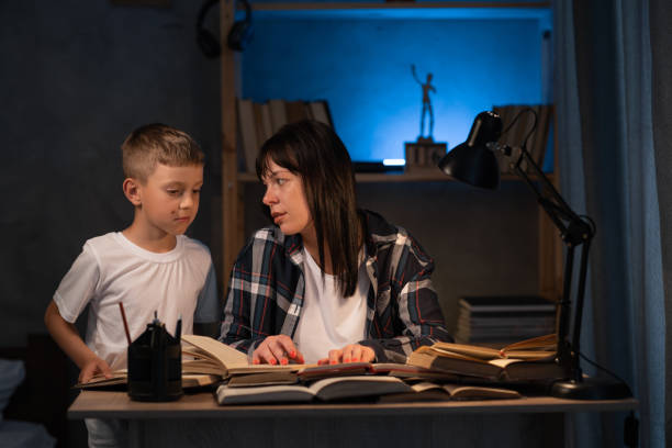 istock mother helping adorable son doing schoolwork at home at night, homeschooling 1407635561