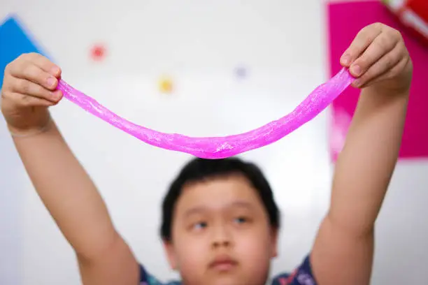 Photo of kid hold slime for play