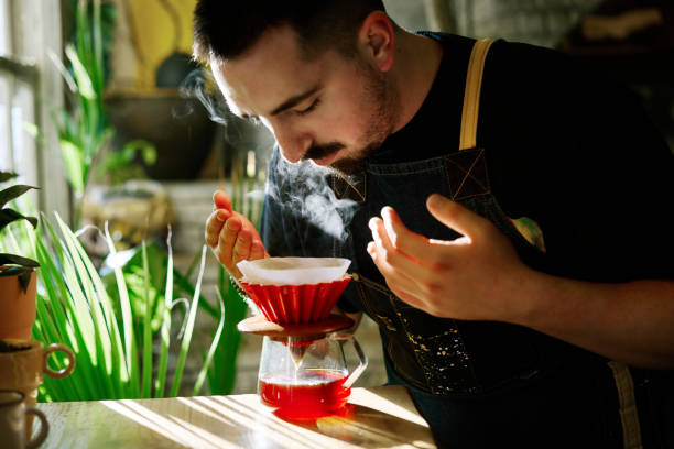 Barista smelling the filter coffee while making it Professional barista preparing filter coffee using origami dripper. Alternative ways of brewing coffee smelling stock pictures, royalty-free photos & images