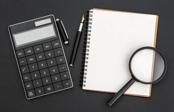 istock Notepad with calculator and magnifying glass. Business concept. 1407638247