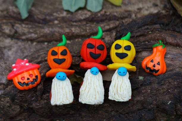 istock Figures of three dwarfs decorated with a pumpkin on a background of tree bark. 1407638472