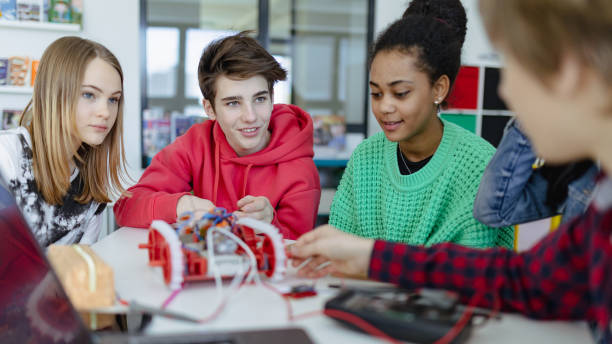 istock Group of high school students building and programming electric toys and robots at robotics classroom 1407640512