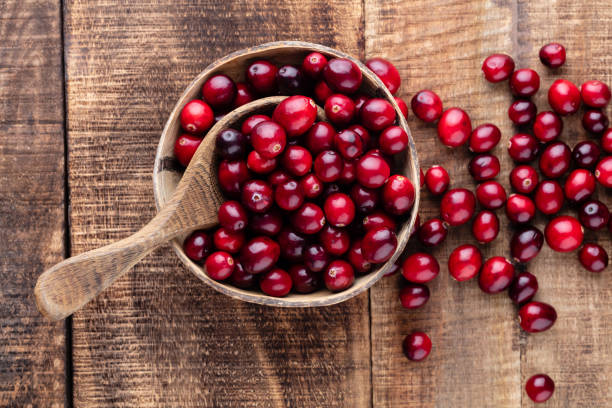 istock Red cranberries on wooden background. Brries in a bowl. 1407646652