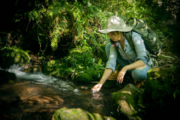istock Woman drinking water from mountain stream 1407649248