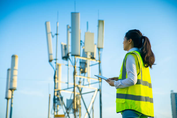 engenheiro trabalhando em uma torre de telecomunicaç�ões - torre de comunicações - fotografias e filmes do acervo