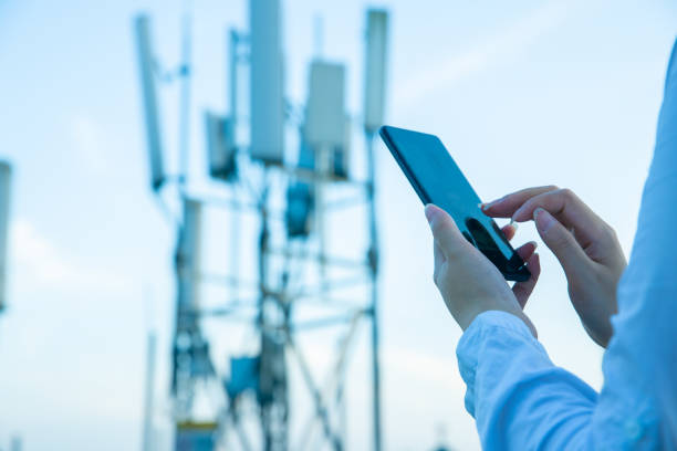 istock Human hand using mobile phone near 4G,5G communications tower 1407650630
